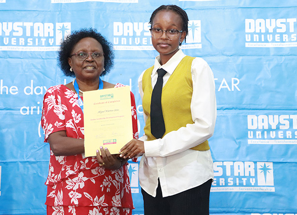 DVC ARSA Prof. Faith Nguru presents a certificate to one of the Excandidates during the graduation