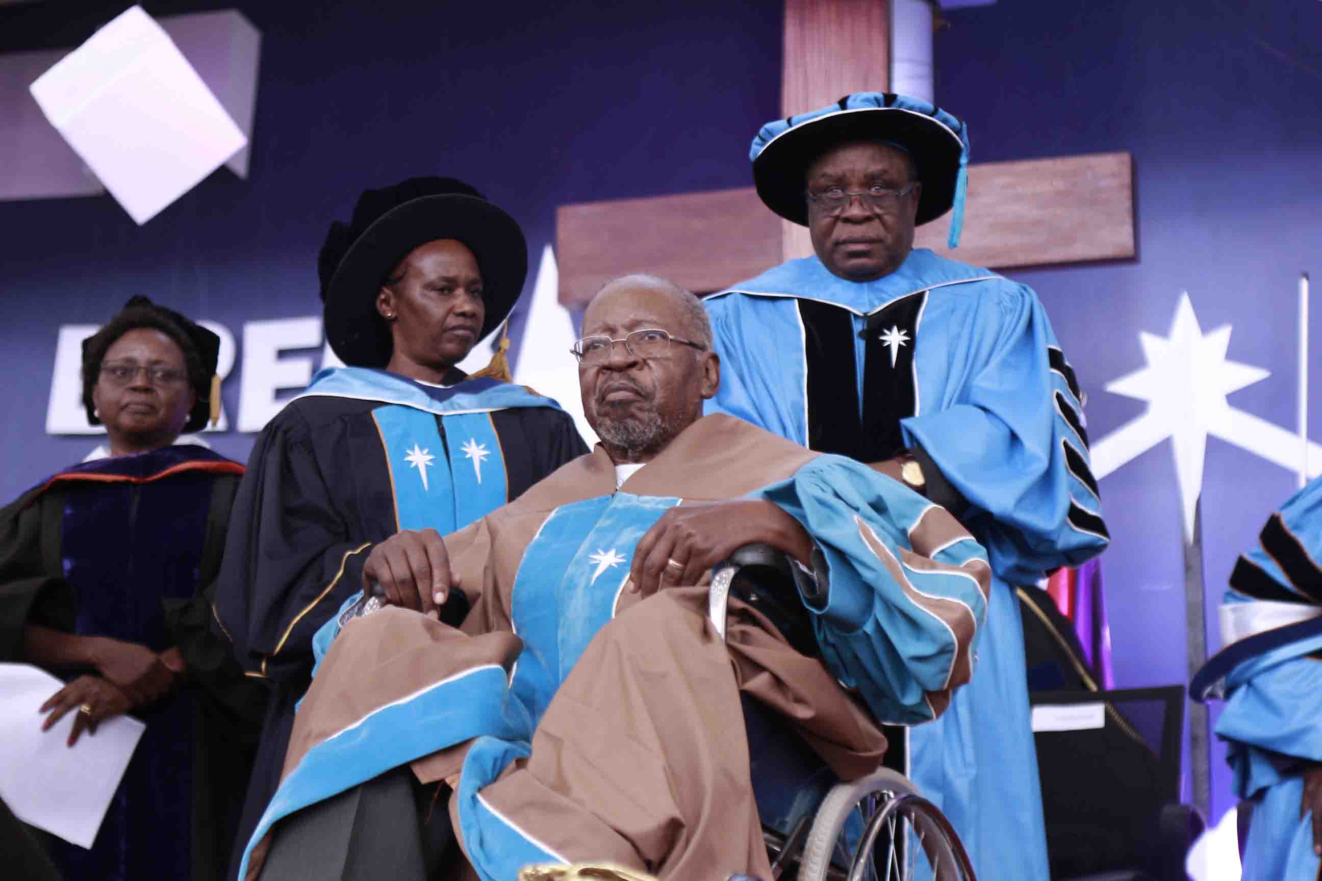 Prof. Stephen EJL Talitwala being conferred Honorary Degree of Doctor of Laws during the 42nd Graduation Ceremony in 2019, by the Chancellor, Prof Mary Murimi (left) and Vice-chancellor Prof Laban Ayiro (right)